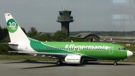 Ein grünes Flugzeug mit der Aufschrift #flygermania am Flughafen Rostock-Laage (dpa-Zentralbild)