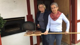 Die Hobby-Bäckerinnen Maria Schwarze-Kaufmann (rechts) und Sigrid Schindler holen die Brote aus dem Elektro-Ofen im Backhaus Bobenheim am Berg (Pfalz) (Deutschlandradio / Anke Petermann)